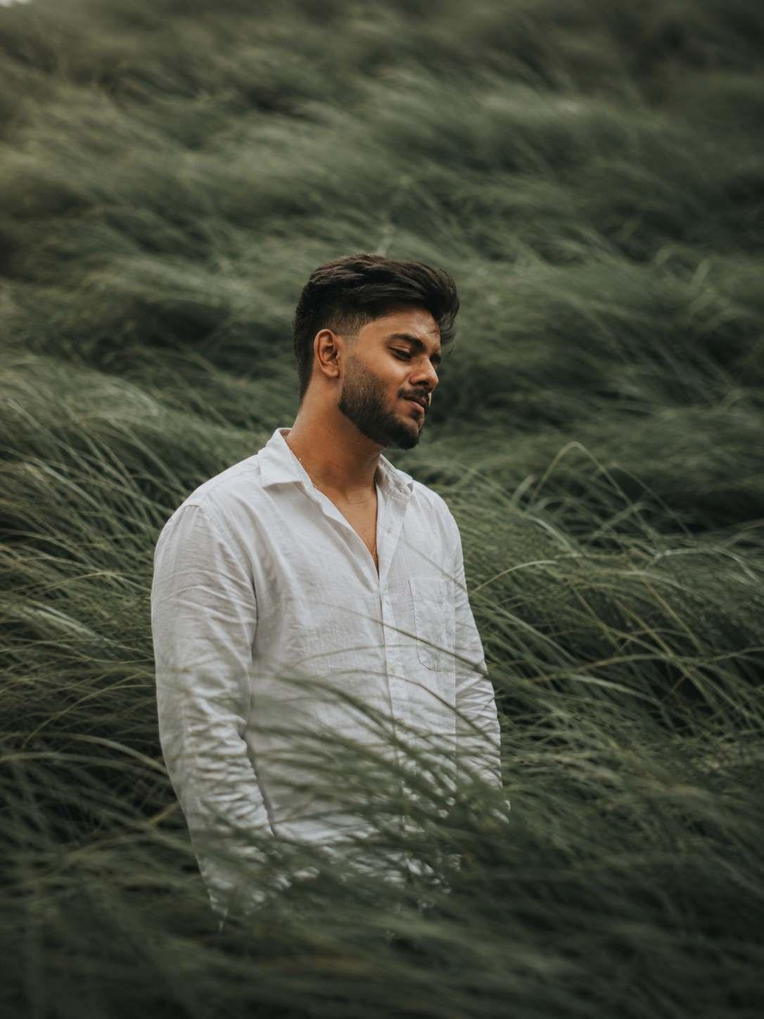 Dakshesh B, Frontend Web Developer, standing in a grass field